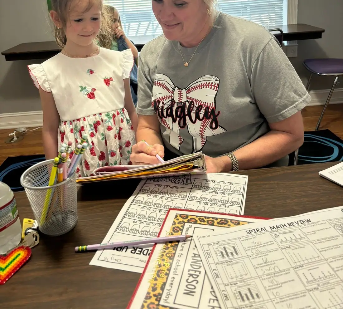 A teacher works one on one with a student on a reading worksheet